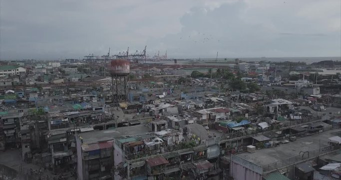 Ungraded, Aerial flight over poor housing area towards harbour. Drone, 4K.