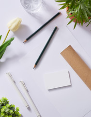 Mockup branding identity include white background with name card, letterhead, pen, plant. Top view angle. For mockup work : branding identity, name card, letterhead, table work top view ...