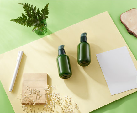 Cosmetic product mockup set with green light background, pen, yellow paper, notebook, plant. Mockup for presentations and portfolios. Front view angle. - Powered by Adobe