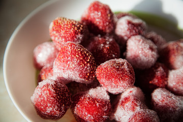 A full plate of strawberries covered in frost