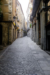 Fototapeta na wymiar Nobody on a famous old town cobble stone narrow straight street in Girona