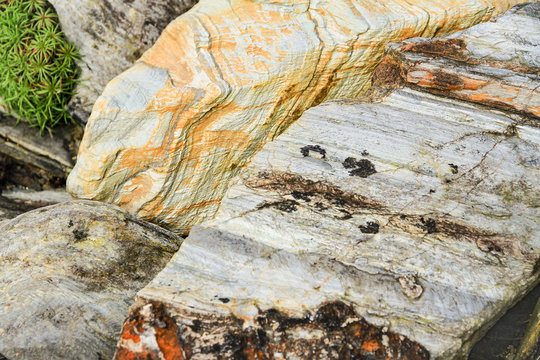Detailaufnahme von bunten, ausgewaschenen und erodierten Felsen an einer K&uuml;ste