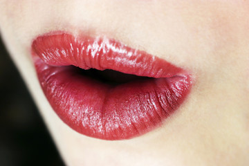 An up-close picture of an opened lips with red lipstick