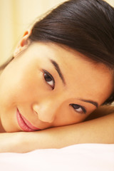 Obraz premium An Asian woman resting her head on her hand