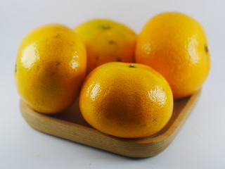 Four orange in wooden plate on white background