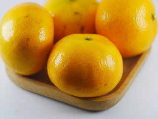 Four orange in wooden plate on white background