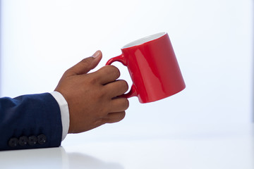 Businessman holding a coffee cup on the white table at the office
Concept: planning meeting working professional,
beverage cafe breakfast for working, looking space to a morning lifestyle workplace 
