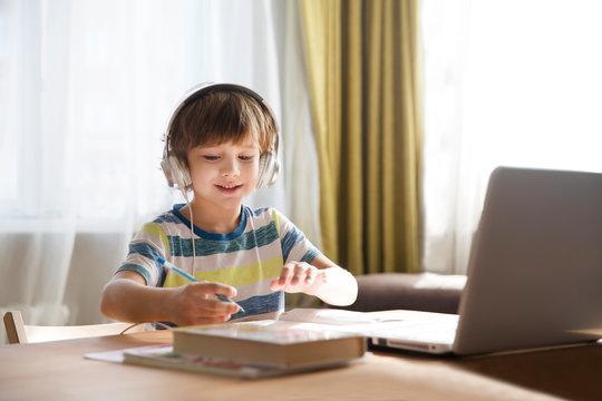 child boy is using a laptop and study online at home. homeschooling, distant learning - Powered by Adobe