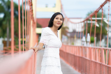 Portrait of Asian woman smiling and relaxing on rope bridge