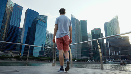 Young Man Looking At Singapore City Skyline During Sunset