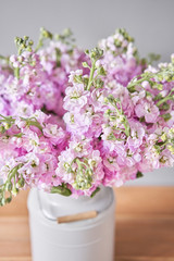 Bouquet of Beautiful lilac mattiola. Spring flowers in vase on wooden table. Flowers delivery.