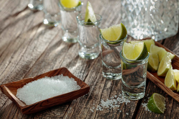 Fototapeta na wymiar Tequila with salt and lime on a old wooden background.