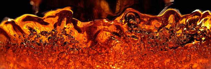 Carbonated drink in glass, abstract splashing.