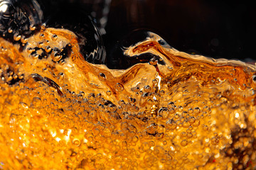 Carbonated drink in glass, abstract splashing.