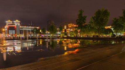 Water fountains and city lights with reflections in North Square, Xi'an, China at night