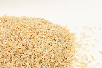 The lower left corner is filled with a pile of long-grain, brown rice placed on a white background. The concept of background to describe the news.