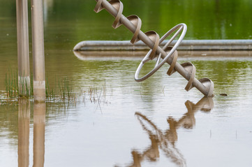 view of an excavated lake with a special focus on a reflective toy for children that can carry water from the shore with overcast skies and calm water in northern Germany