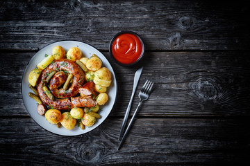 Sausage with new potato on a plate, copy space