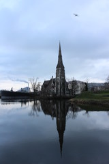 Fototapeta na wymiar Castle in Copenhagen, Denmark reflecting off a canal water during a cloud day in February