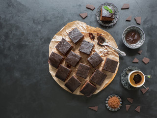Chocolate brownie cake with black coffee, dessert on black background.