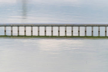 View of a quarry pond with a special focus on a reflective marking for non-swimmers from the shore with cloudy skies and calm water in northern Germany