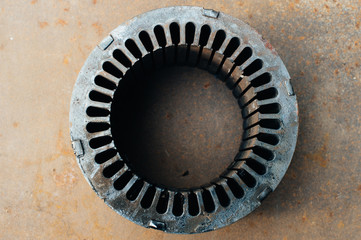 Old charred motor stator core with grooves. Scrap metal. Close-up. Macro