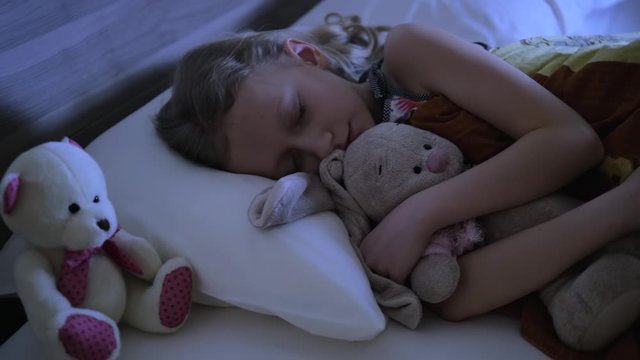 little girl sleeping with her favorite toys, Kid sleeps in bed at night