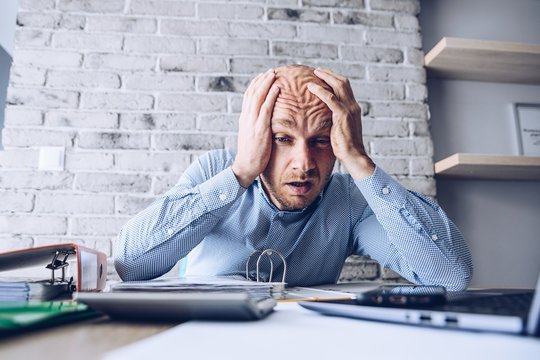 Crying businessman stressed about bankruptcy debt.