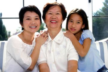 Girl posing with her mother and grandmother