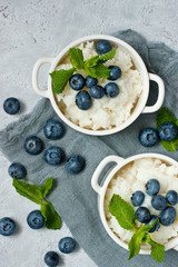 Served creamy rice pudding with mint leaves and  blueberries