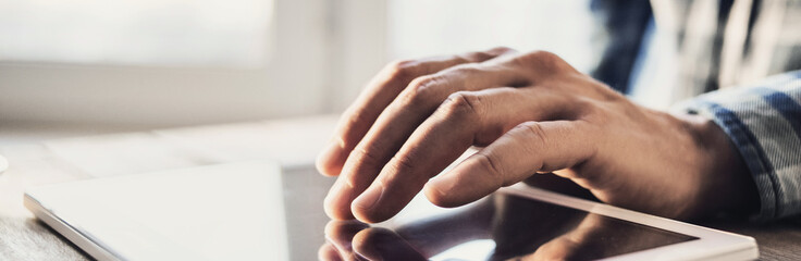 Using digital tablet, businessman or student using tablet computer at home, panoramic banner, online learning, internet marketing, working from home, office workplace freelance concept