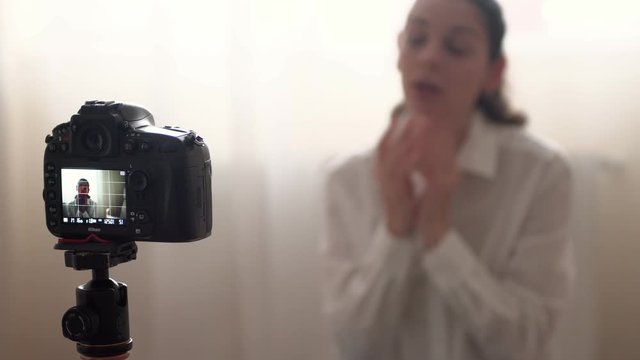 Attractive caucasian woman famous blogger is recording video for her online vlog using camera home