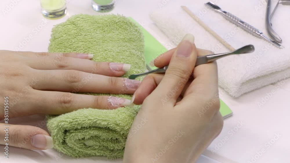 Wall mural Manicure. Push back the cuticle with a metal pusher. Manicure tools, nail polishes, oil. Home nail care, SPA, beauty. Long natural nails. Beauty salon.	