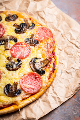 Freshly making pizza with mushrooms served on the rustic background. Selective focus. Shallow depth of field.