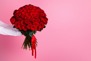 Photo of cropped man arms hold big one hundred red bright roses bunch giving secret admirer...