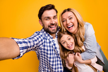 Closeup photo of mom lady handsome dad little daughter spend quarantine together taking selfies having fun bloggers hugging laughing wear casual shirts isolated yellow color background