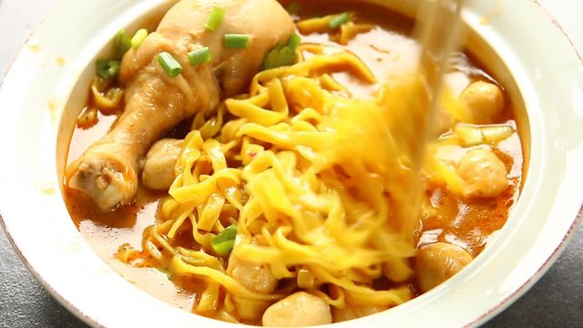 Curried noodles soup with chicken or Khao Soi , Thai northern famous food