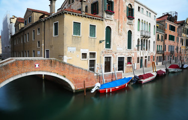 Fototapeta na wymiar Navigable canal in Venice with boats photographed with the long