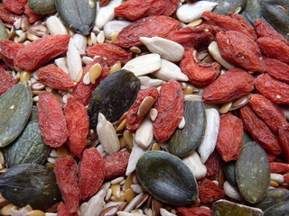 Goji and green pumpkin seeds mix close up background