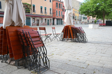 Tables and chairs of an outdoor cafe without tourists due to the