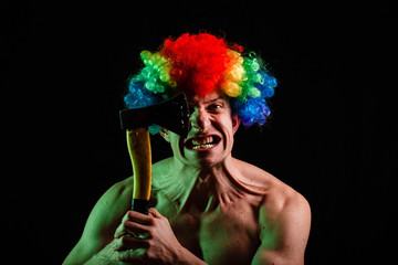 Crazy clown with an ax. Clown with an ax. Crazy. Psycho. Crazy man with an ax on a black background.