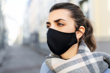 health, safety and pandemic concept - young woman wearing black face protective reusable barrier...