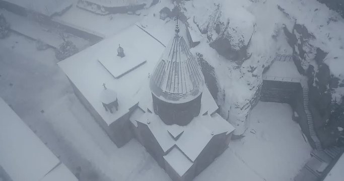 old Armenian Christian stone Church in the snow on the mountain in winter