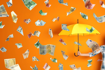 Woman holding umbrella under money rain on color background, closeup