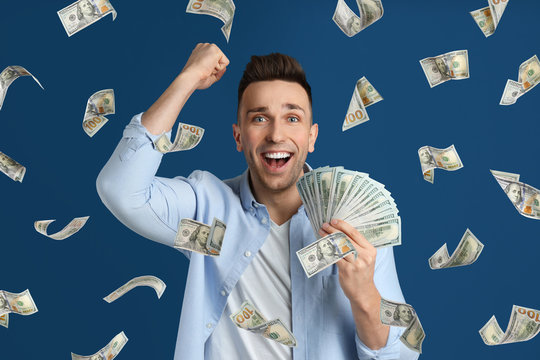 Man with American dollars under money rain on blue background