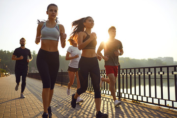 A group of young people are running in the park.