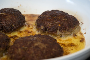 Frikadellen Gemüse Fleisch Paddys mit Kurkuma beim Anbraten in weißer Teflonpfanne mit Kokosöl, Produktbild