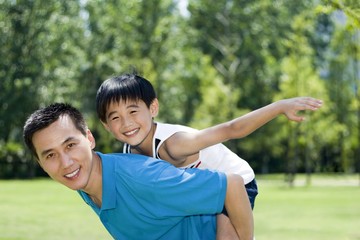 Father carrying son on his back