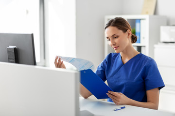 medicine, technology and healthcare concept - female doctor or nurse with clipboard working at...