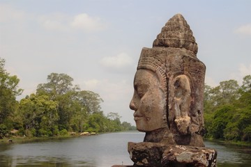 Fototapeta premium Stone statue Deva at the south gate of Angkor Thom, Angkor Wat. Overlooking the Moat